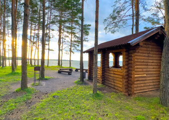 Summerhouse for rent on vacation at sea. Wooden house for recreation in nature. Camping area with Wooden gazebo for rest on river. Wooden Arbour for camping. Timber Wood Pavilion in forest at lake.