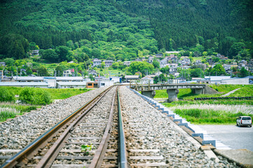 線路と田舎の集落を望む初夏の風景