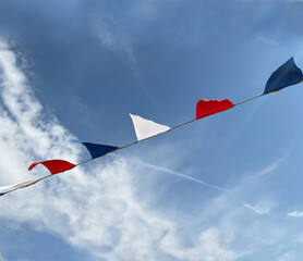 Bunting flags in red, white and blue against a summer sky