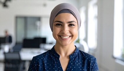 Positive office worker in headscarf smiling in inclusive work setting