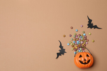 Halloween with orange pumpkins, black bats, autumn leaves on beige background