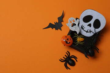 Halloween with orange pumpkins, black bats, autumn leaves on orange background