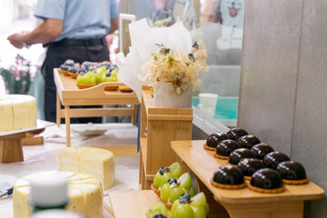 A colorful and delicious buffet spread featuring a wide variety of international dishes, including fizzy cola, lemon tart, creamy cheesecake, blueberry tart, crispy fried chicken, and savory pasta