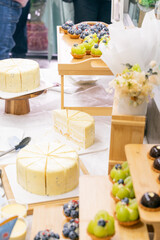 A colorful and delicious buffet spread featuring a wide variety of international dishes, including fizzy cola, lemon tart, creamy cheesecake, blueberry tart, crispy fried chicken, and savory pasta