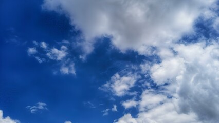 Vibrant blue sky with dynamic white clouds. Perfect for backgrounds, nature themes, or concepts of freedom and open space. Ideal for design, advertising, and digital projects