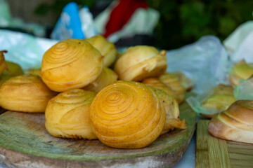 Traditional smoked cheese rolls on market stall
