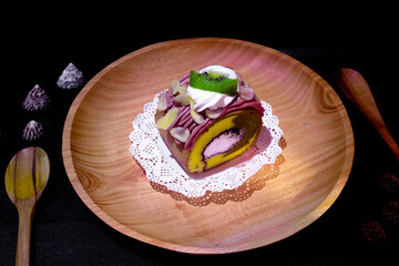 Indonesian sweet cakes served on natural wooden plate and spoon with black background highlighting...