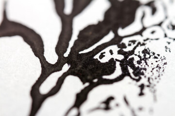 Extreme close up of black acrylic paint texture on paper. Selective focus.