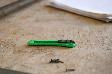 Green cutter on a wooden table at work