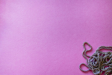 Furniture, beads for diy A collection of shiny chains rests on a bright pink surface, creating an...