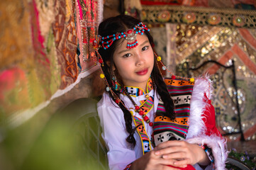 Young pretty Mongolian girl in colorful traditional Mongol costume in tepee house