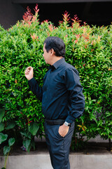 Man admiring vibrant foliage in an outdoor setting, natural light illuminates the scene with