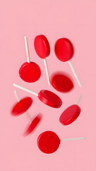 red round lollipops falling from above in pink background