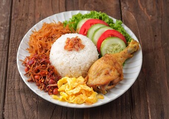 Nasi uduk is a dish made from diaroned white rice steamed with coconut milk, and seasoned with...