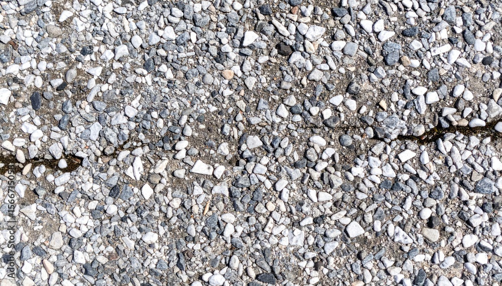 Poster close up of chipped concrete surface with exposed aggregate showing crack and varying tones of grey 