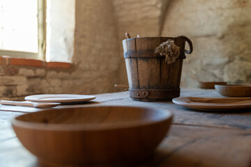 Rustic wooden table setting with bucket and bowls in natural light