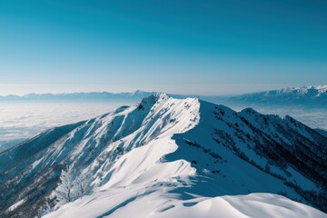Fototapeta premium A mountain covered in snow with a clear blue sky in the background