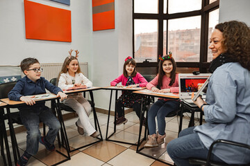 Woman teaching a group of elementary students at language school