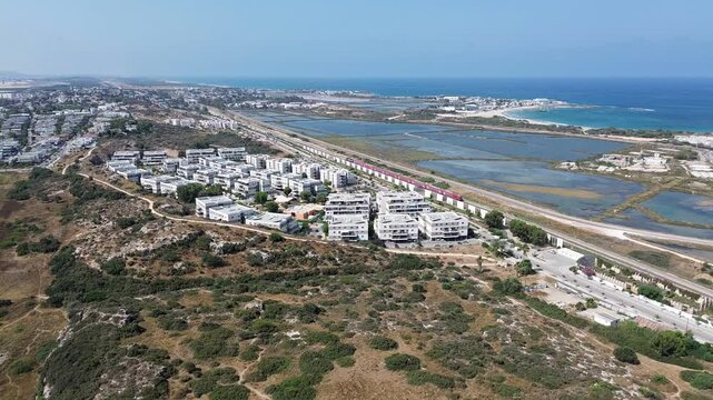 Aerial footage of Atlit a coastal town located south of Haifa, view with salty ponds and red train moving towards to Tel Aviv, Israel, Mediterranean sea