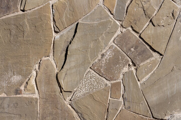 Various shapes of natural stone create an abstract background. The design features muted earth tones and subtle variations, offering a rustic and organic feel perfect for diverse applications.
