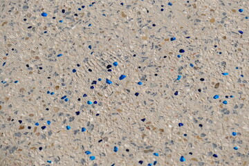 Close-up of a decorative beach pathway made of small natural pebbles embedded in concrete, with...