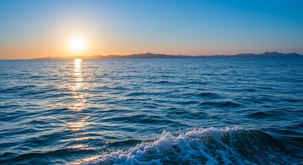 Golden Hour Ocean Wave with Distant Mountains and Sunlit Water
