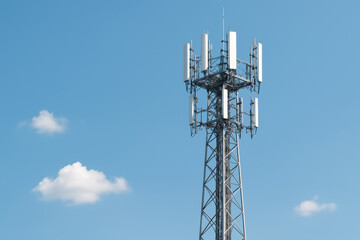 A tall tower with many antennas on top of it. The sky is blue with a few clouds