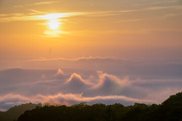 Stunning sunrise over misty mountains in Shilin New Taipei Taiwan, with a faint silhouette of...