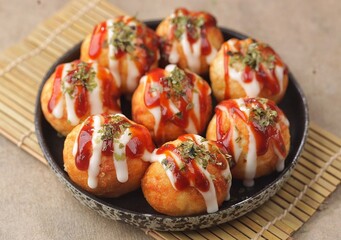 Takoyaki is a typical Japanese snack in the form of small balls made from wheat flour dough and filled with pieces of octopus.
