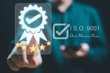 Businessman is interacting with a digital display showcasing ISO 9001 certification and a quality management system for emphasizing a commitment to excellence and quality assurance concept.