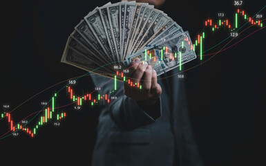 Businessman holding dollar banknote with stock market graph for inflation and interest rating increasing concept.