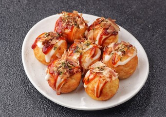 Takoyaki is a typical Japanese snack in the form of small balls made from wheat flour dough and filled with pieces of octopus.