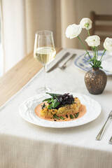 Cauliflower steak with asparagus and sauce with wine on white plate