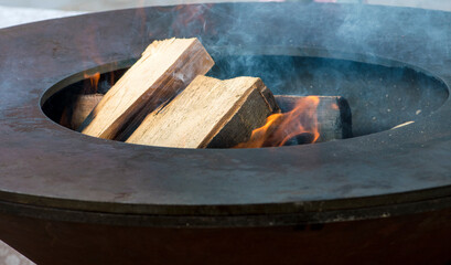 burning stove in a round iron bbq grill