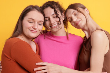 Friends hugging each other on orange background