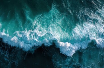 Obraz premium Aerial view of powerful ocean waves crashing, creating a breathtaking spectacle of white foam and deep teal water.