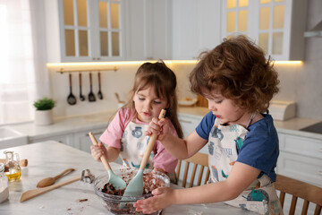 Cooking recipe. Cute children mixing dough for cookies at table in kitchen