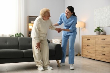 Obraz premium Nurse assisting senior woman indoors. Home health care service