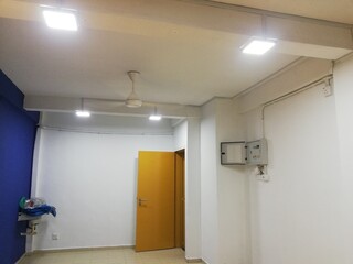 Apartment renovation interior showing wall repainting, lighting setup, furniture arrangement, and bathroom upgrade in clean modern living space