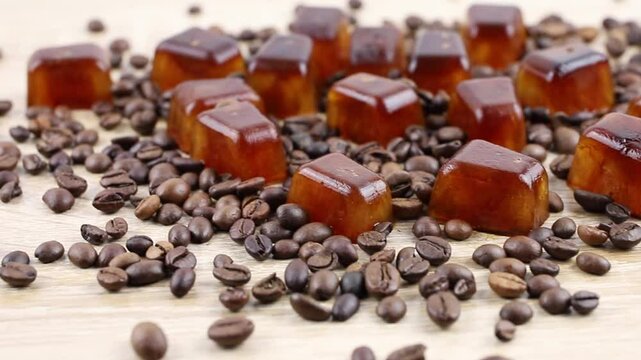 Side view of coffee ice cuber scattered on table, decorated with coffee beans. Studio shot. Concept of coffee ice cubes for making iced coffee.