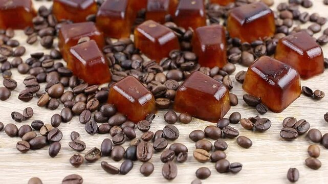 Side view of coffee ice cuber scattered on table, decorated with coffee beans. Studio shot. Concept of coffee ice cubes for making iced coffee.