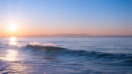 Fototapeta premium Golden sun rays illuminate ocean waves at sunset with distant hazy mountains golden hour