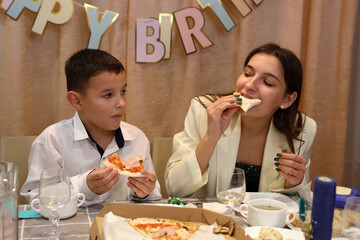 Celebrating a boy's birthday, the family sits at the table, drinks and treats. Birthday...