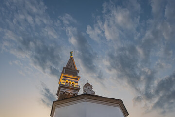 St. George's Parish Church in Piran at the evening light, Slovenia. historic church tower illuminated at twilight with artistic