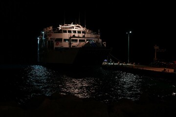 Woman Observing Water Near Moored Ship at Night