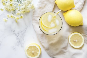 Refreshing lemonade with ice and fresh lemons on marble tabletop with flowers