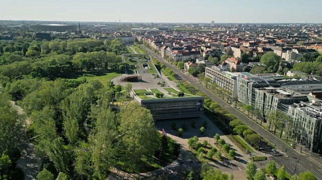 Drone video zooming in on the Museum of Ethnography during sunrise, highlighting the curved architecture with City Park and Pusk&aacute;s Ar&eacute;na softly visible in the background.  