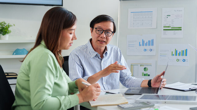 Asian Adult Business Leaders Discussing ESG Strategy In Modern Office Meeting And Analyzing Data For Sustainable Growth