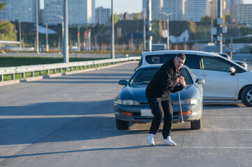 Caucasian man pulling a car with a rope. 