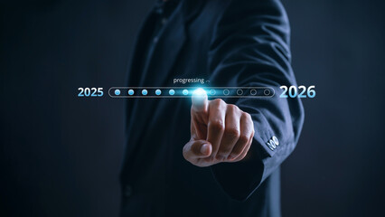 Businessman touching digital progress bar from 2025 to 2026 symbolizing future planning, strategic...